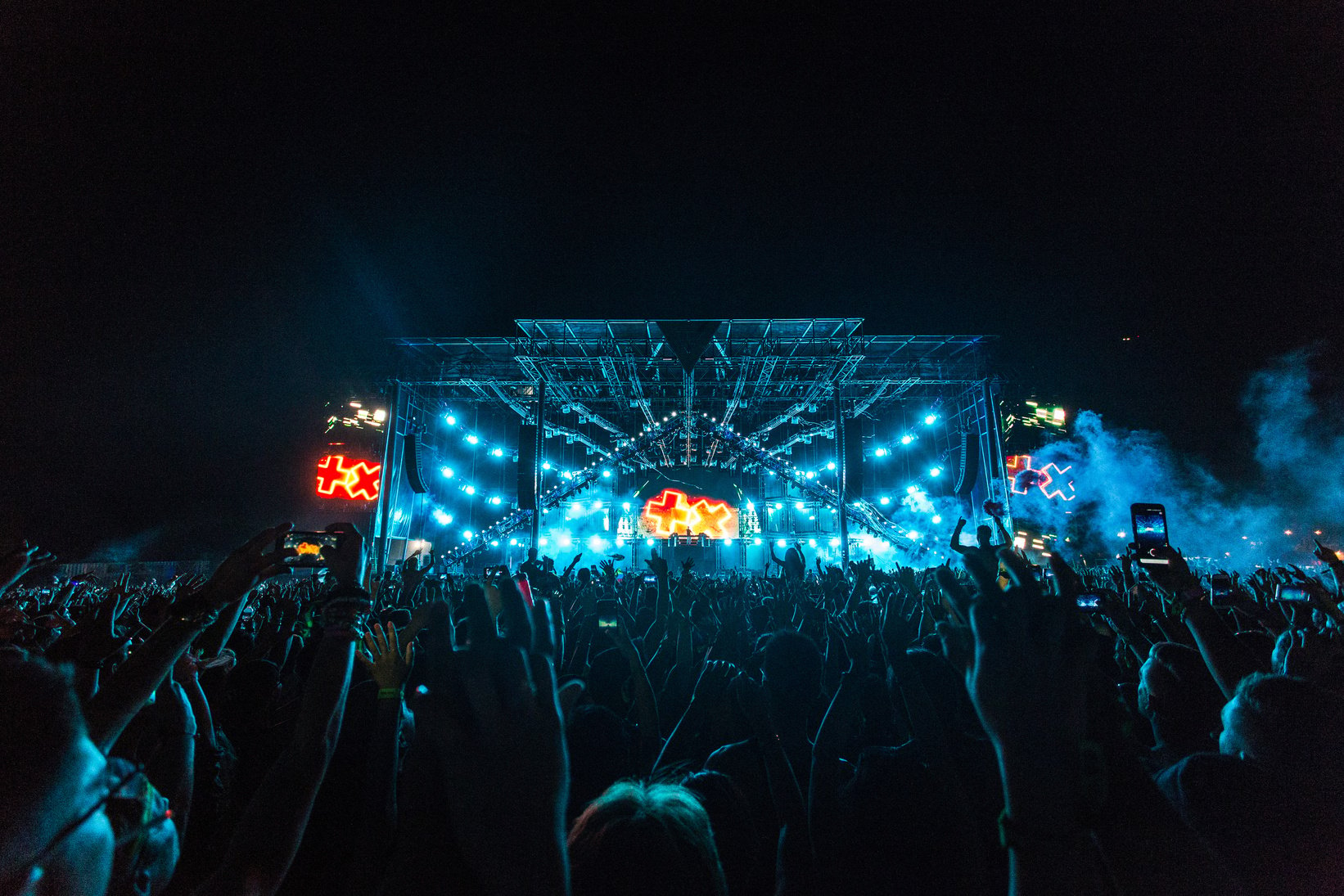 Crowd in Front of Blue and Orange Stage during a Concert at Night